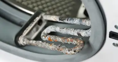 Limescale damage to a washing machine heating element.